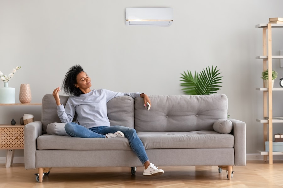 Young woman sitting on the couch with the very best indoor air quality.