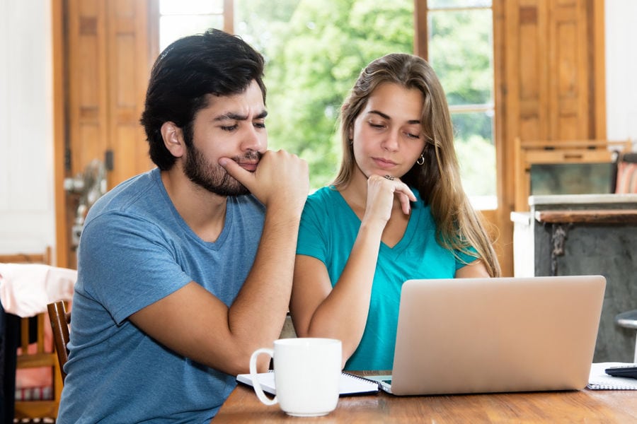 Couple confused by their laptop.