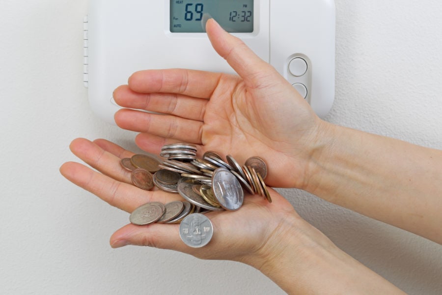 This is a photo showing coins being saved in front of a thermostat.