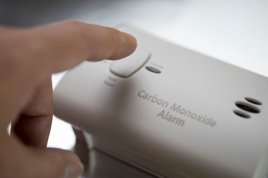 A person presses a CM alarm. Learn the Facts About Carbon Monoxide.