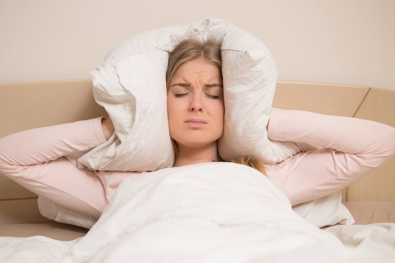 Air Conditioning Noise Concerns. Women covering her ears.