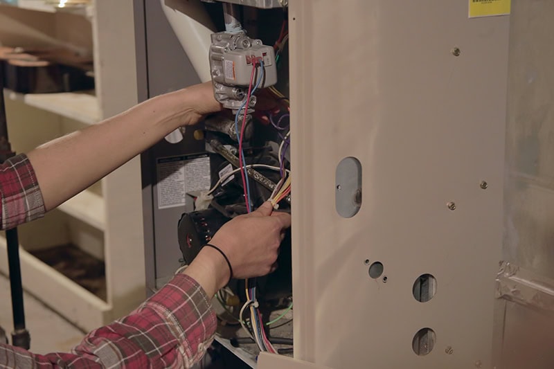 HVAC service tech working on unit.